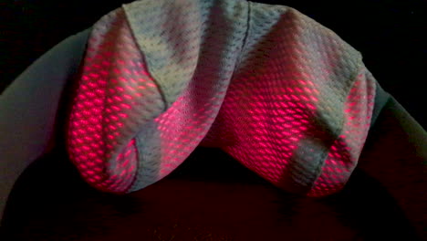 closeup of a neck massager with infrared light moving and rotating