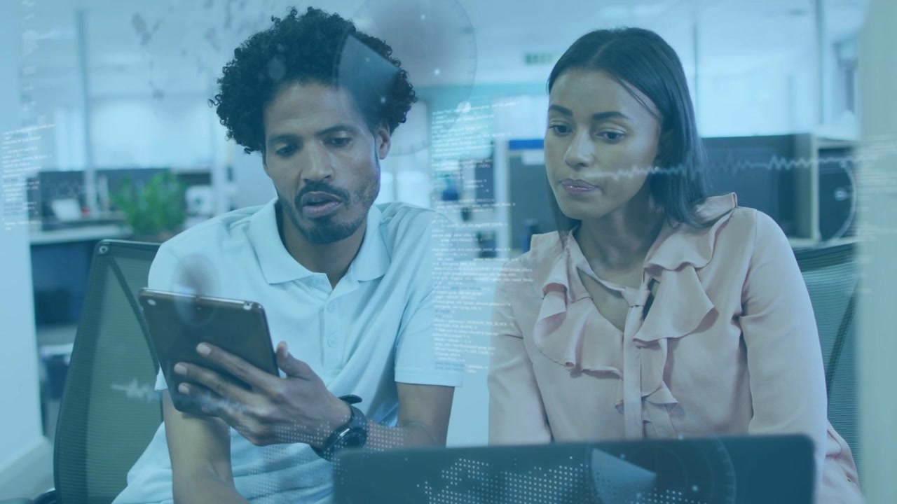 Man presenting tablet initiating team review, woman following, tapping tablet, glancing laptop