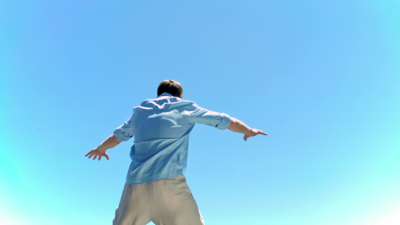 스트래들 포지션에서 느린 동작으로 점프하는 남자