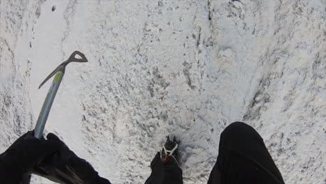 feet of an alpinist walking on ice, on the glacier in the swiss alps with his equipement