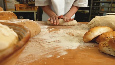 female baker kneading a dough