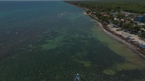 Boats-navigating-along-Guayacanes-Beach,-San-Pedro-de-Macoris-in-Dominican-Republic