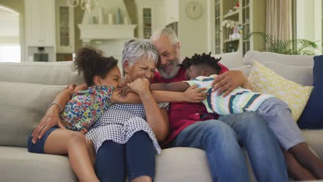 grandparents embracing their grandchildren at home