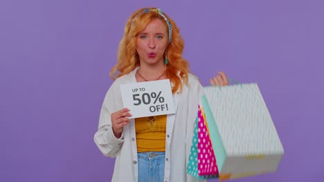 Cheerful-redhead-girl-showing-shopping-bags,-Up-To-50-Percent-Off-inscriptions-banner,-Black-Friday