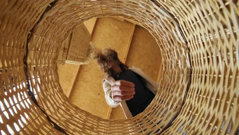 inside shot of a wicker basket, woman opens the wicker basket and reaches inside then closes it