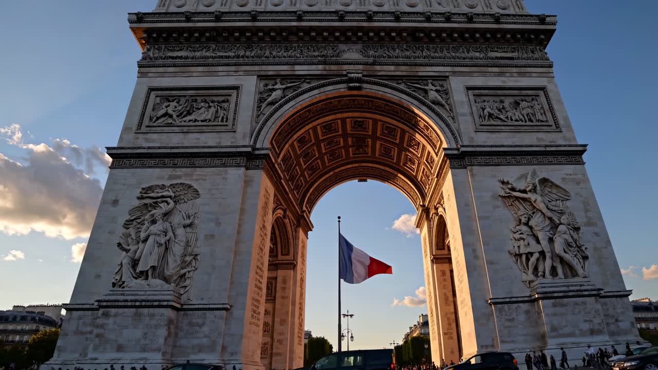 Toma de video en contrapicado del Arco del Triunfo al atardecer, capturando su grandeza y detalles intrincados