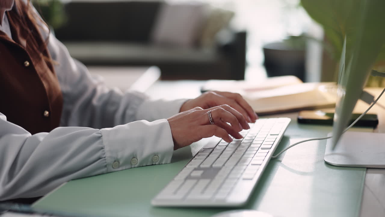 Kvinne som skriver på et datamaskintastatur ved et skrivebord