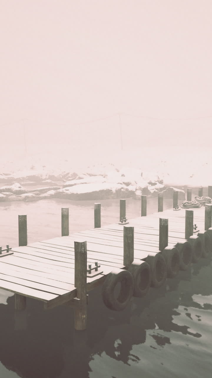 Foggy winter morning on a secluded dock with snow covered surroundings