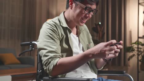 man in wheelchair playing a mobile game