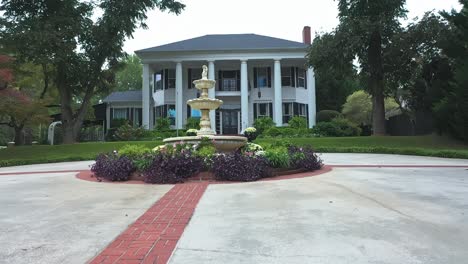 fountain in front of the estate at elegant occasions in hogansville, georgia. - aerial ascend shot