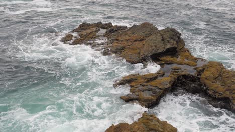 cámara lenta, plano general de las olas del océano rompiendo en la orilla oscilante