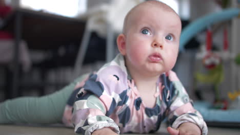 hermosa niña de ojos azules en el piso de su casa, vista de cerca