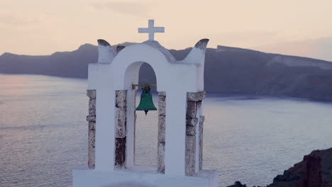 a greek church looks out over the mediterranean sea in oia, santorini at sunset