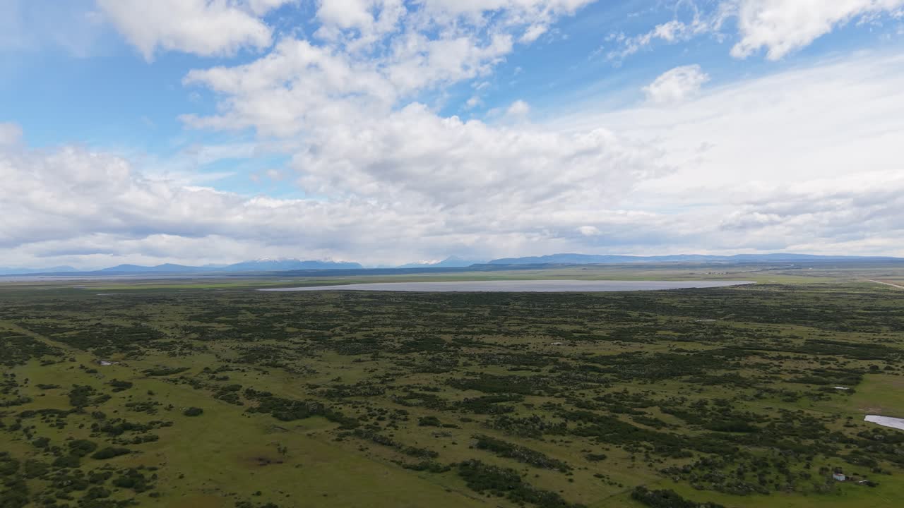 Bredt luftfoto af chilensk Patagonien nær Última Esperanza, Magallanes – åben steppe og laguner med fjerne Andesbjerge under dramatiske skyer