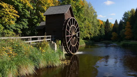 old wooden watermill in autumn forest
