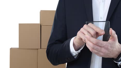 animation of businessman using clear digital tablet with stacks of boxes on white background