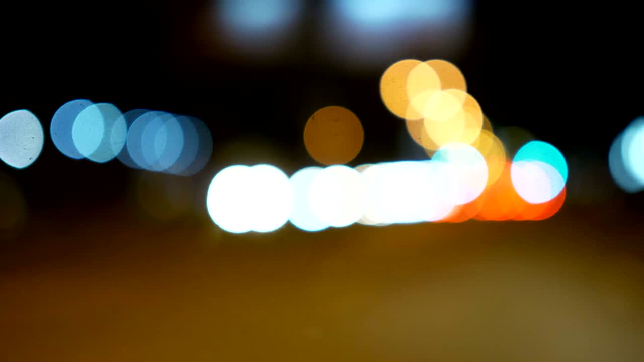 conducir un coche a través de la carretera de la noche, la autopista. luces desenfocadas calle de los ángeles resumen. ciudad fondo borroso. movimientos círculos bokeh de tráfico nocturno.
