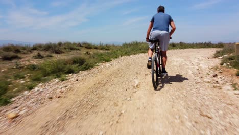 aerial view following with the drone a man on mountain bike