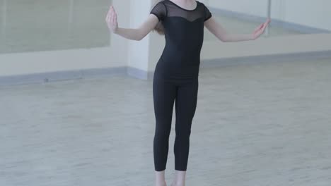 young ballerina practicing dance moves in studio