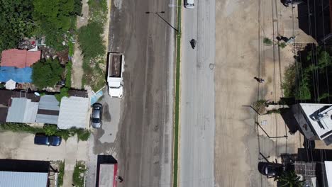 Light-traffic-on-Tulum's-main-road-with-cars-driving-in-Mexico,-aerial-top-down