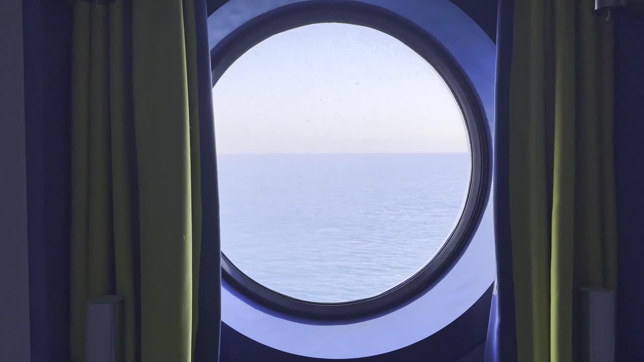 A quiet view through a ship’s window — the open sea, soft movement, and calm waters. A moment of stillness during a journey across the ocean