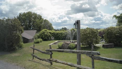 Walking-up-the-driveway-following-a-old-wood-fence-with-a-beautiful-farm-house-mansion-in-the-distance-and-a-elegant-water-fountain-feature-in-the-middle-of-a-garden-at-the-Strathmere-Wedding-Centre