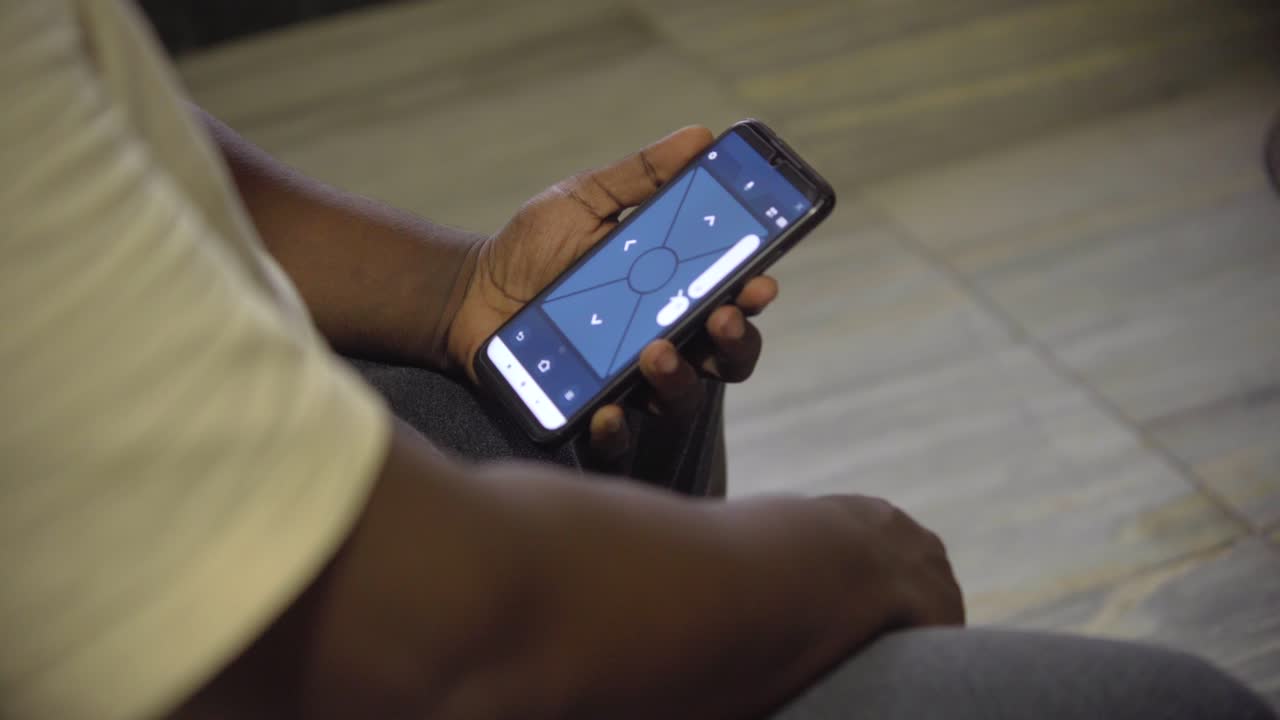 hombre que usa la aplicación remota de asientos móviles firetv para bajar el volumen