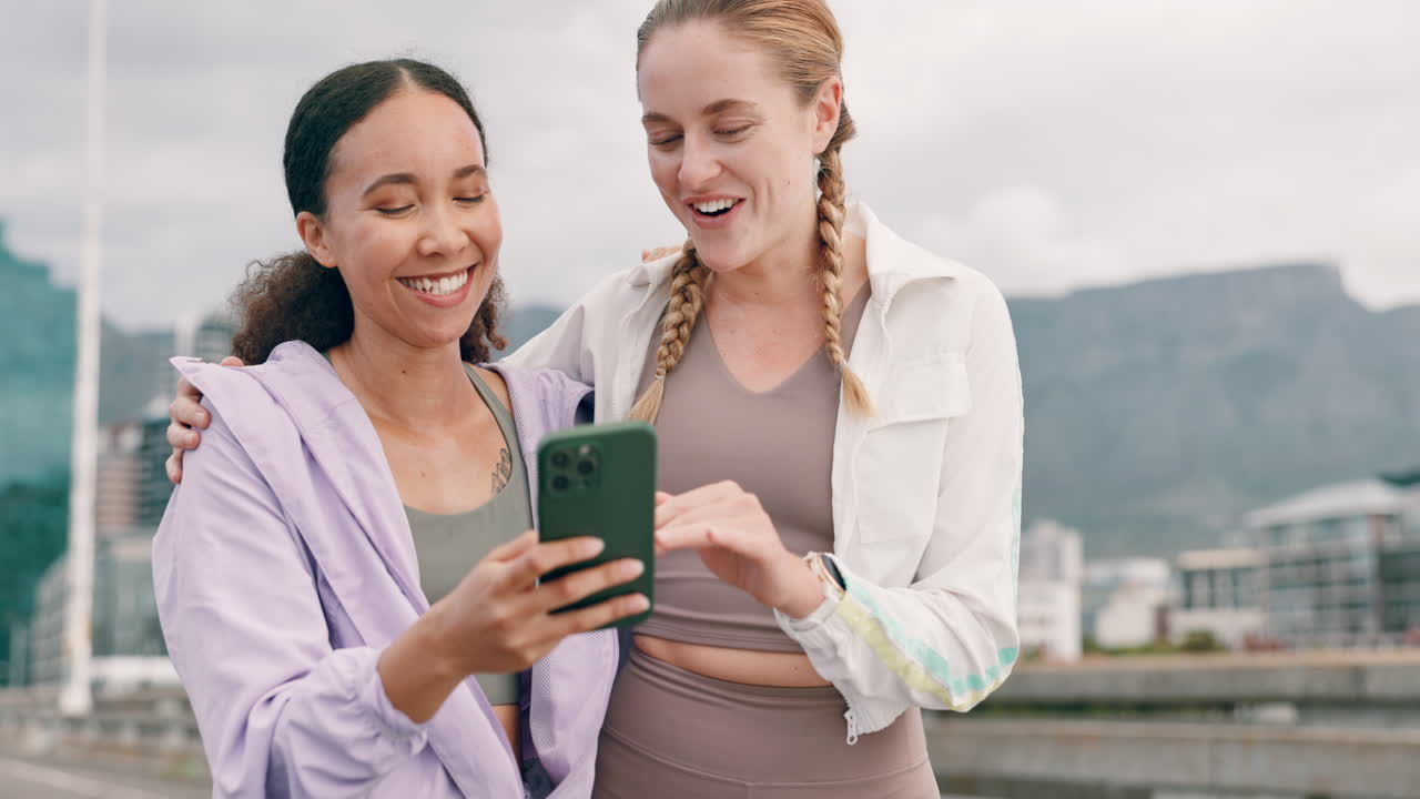 dos mujeres riendo en el teléfono al aire libre