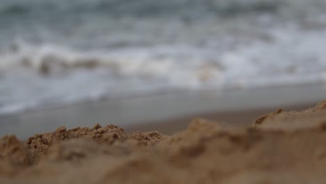 focus pull from slow motion waves to sand in foreground