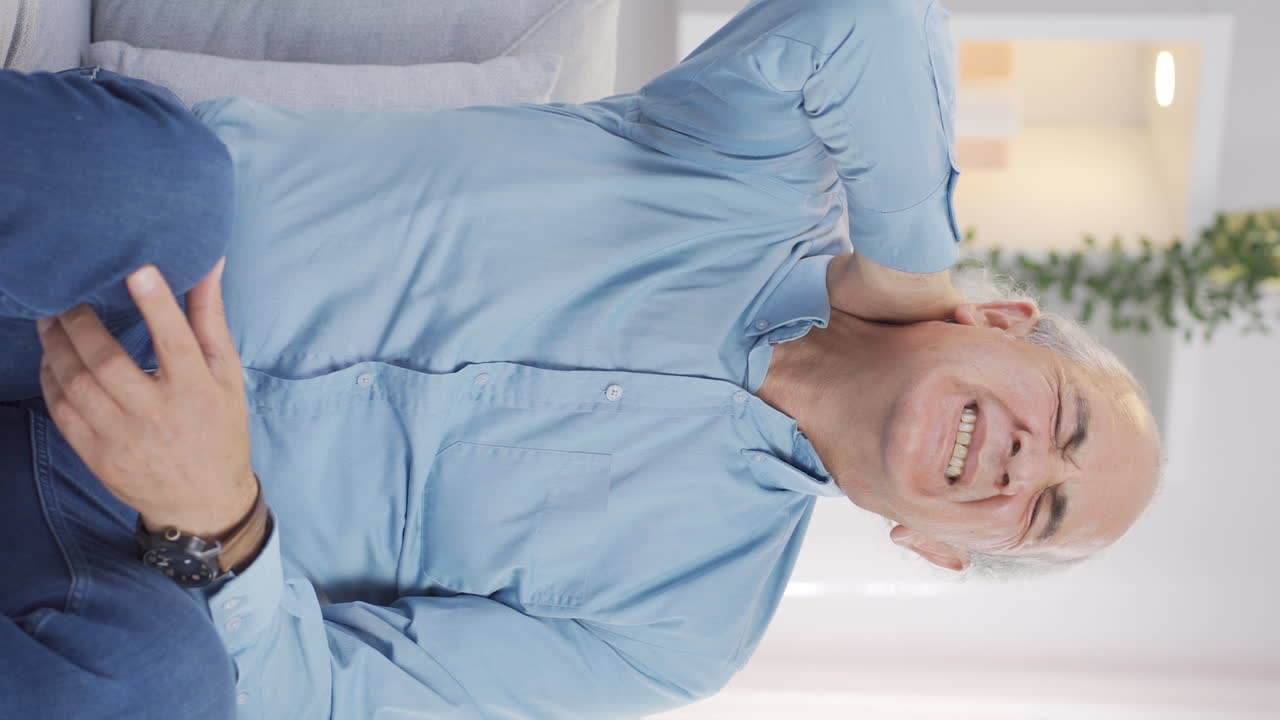 Vertical video of Old man with neck pain.