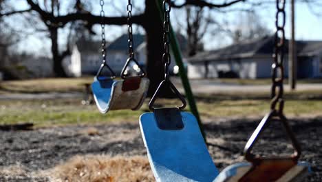 empty swings swaying in a school playground