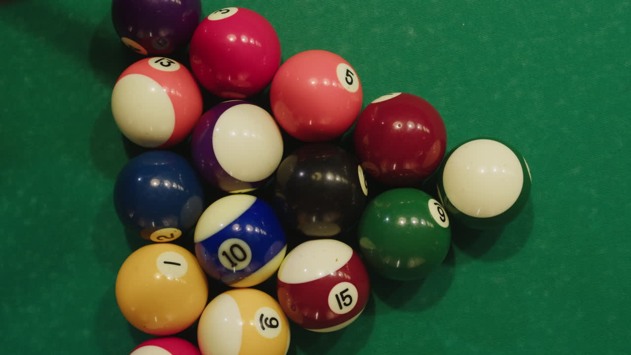 Beginning of game colorful pool balls top view on green billiards table for start to play. American pool, poule. Billiard balls with numbers on a pool table. Billiards team sport.High quality 4k footage
