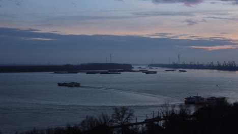 motion timelapse of boats sailing on danube river at the port of galati in romania on a sunset, wide shot