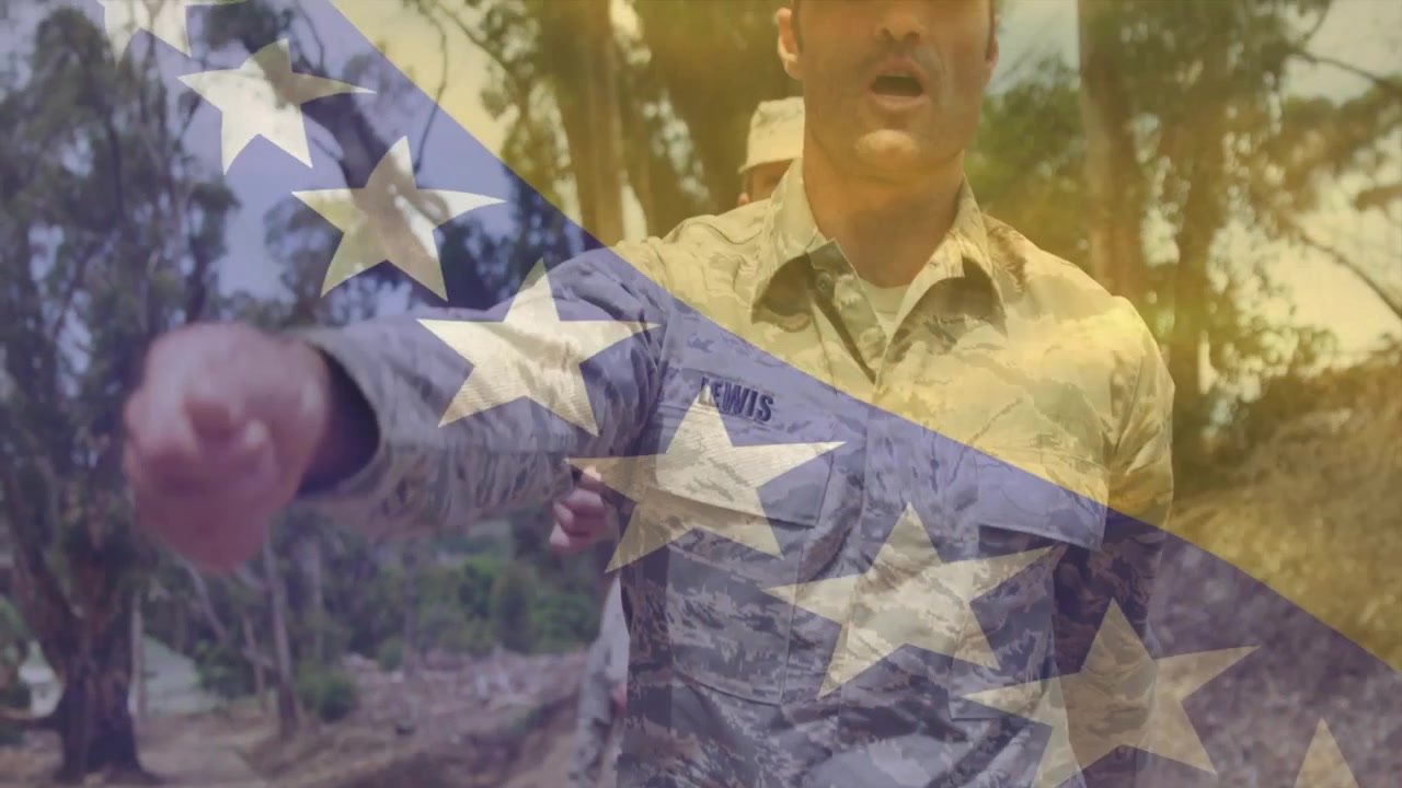 La telecamera panoramica mostra uno stivale che colpisce il terreno fino a un soldato che estende la mano, mostrando la targhetta con il nome Lewis, durante un addestramento militare.