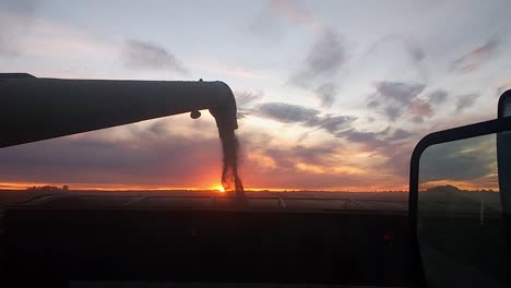 Mähdrescher-Entlädt-Bei-Sonnenuntergang-Getreide-In-Einen-LKW