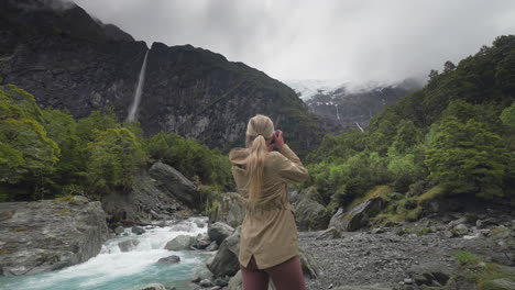 blond female nature photographer stepping into frame at rob roy glacier valley