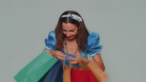 feliz mujer joven sonriente mostrando bolsas de compras, descuentos publicitarios, asombrado con los precios bajos