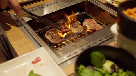 authentic japanese bbq experience – grilling premium wagyu over charcoal, handheld shot