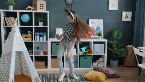 girl dancing with headphones in playroom