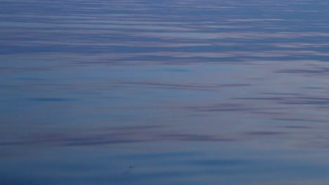 iridescent water ripples in the ocean in thailand in blue hour.