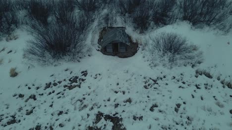 slowly lowering over an abandoned cottage, on a gloomy winter day