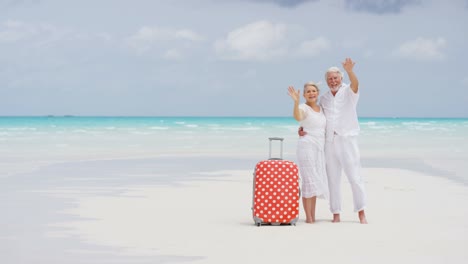 caucasian seniors on beach filming social media video