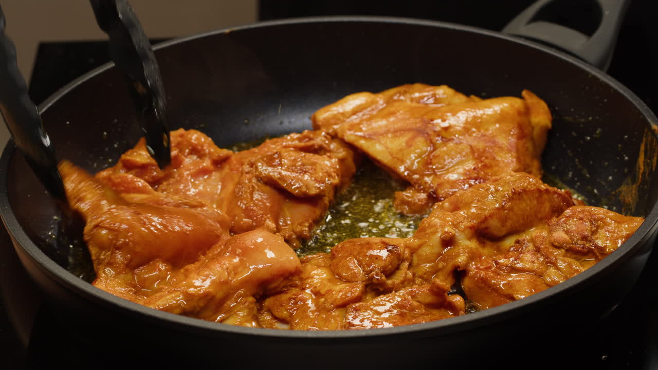 Chicken thighs cooking in frying pan