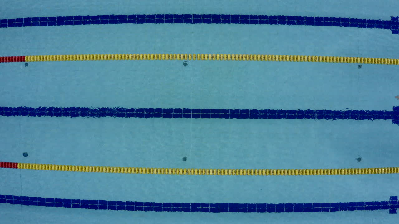 A pool. A person who swims alone. High Angle Shot. Freestyle.