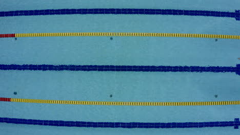 a pool. a person who swims alone. high angle shot. freestyle.