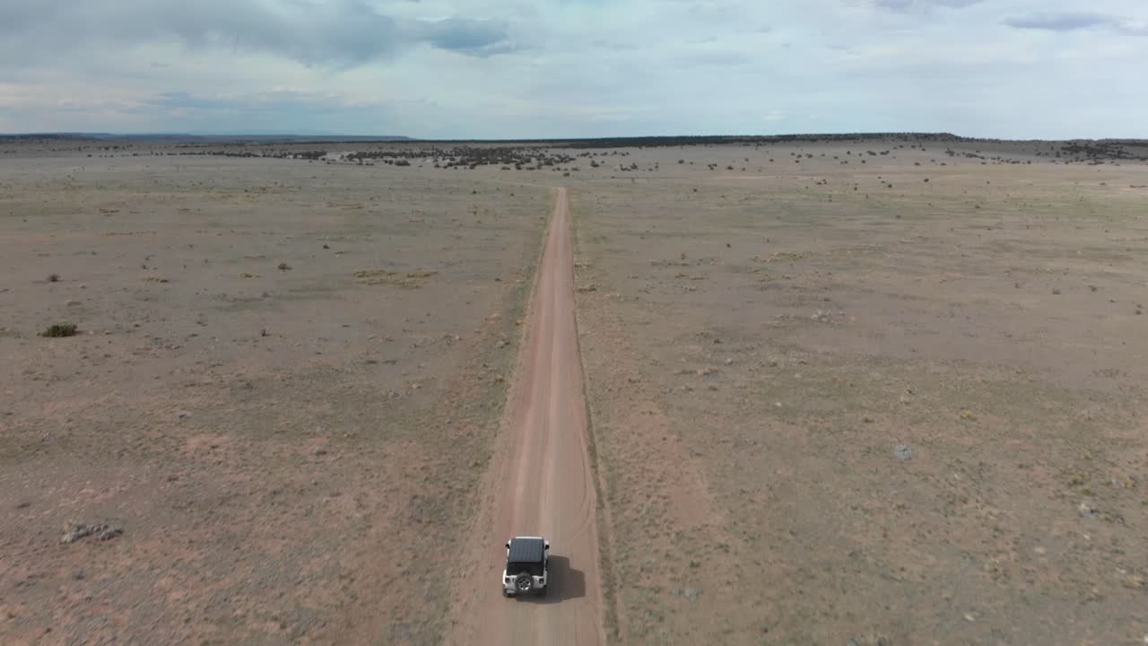 사막 도로에서 지프를 따라가는 틸트 시프트 공중 변화 관점