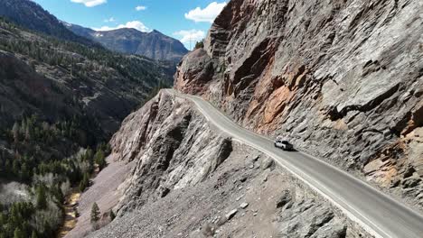 Vista-Por-Drones-De-Un-Camión-Conduciendo-En-El-Borde-De-Una-Montaña-Con-Bordes-De-Acantilados-Expuestos,-Autopista-Del-Millón-De-Dólares,-Ouray-Colorado