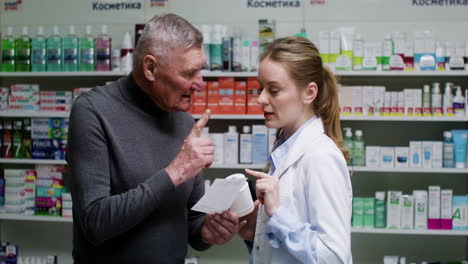 mujer joven hablando con un hombre mayor en la farmacia.