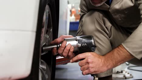 mecánico arreglando una rueda de coche