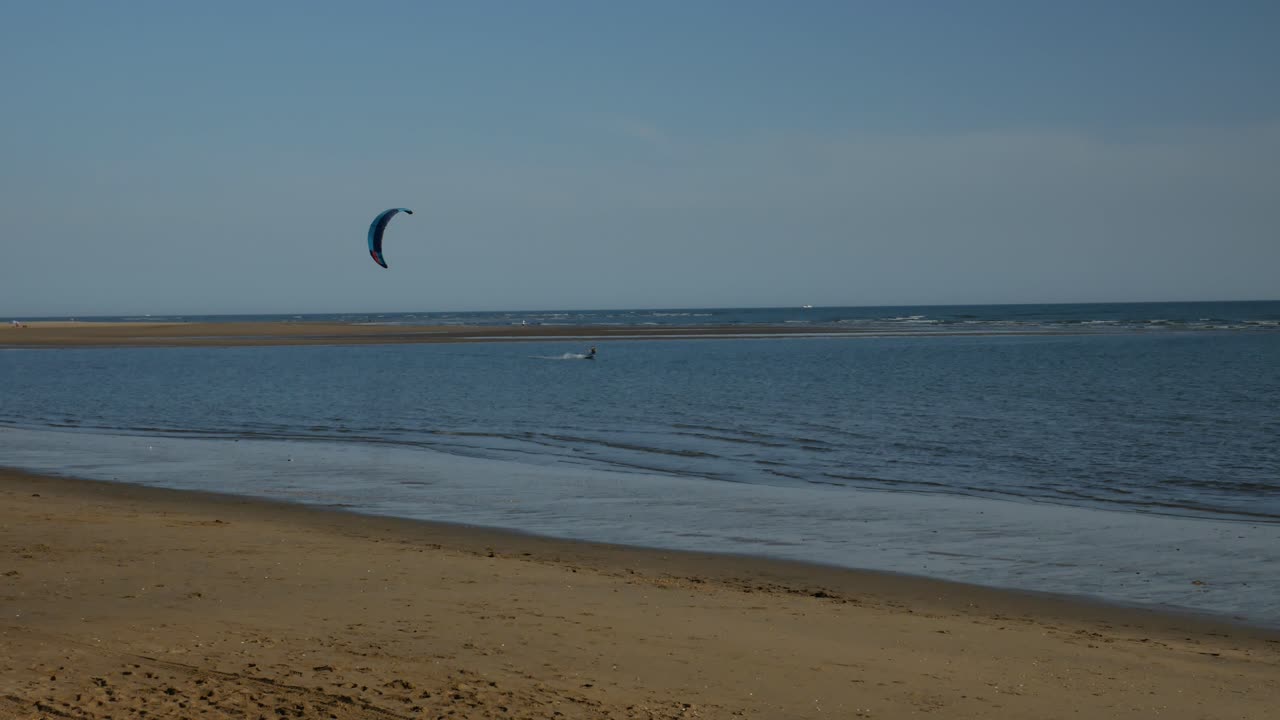 un kitesurf moviéndose hacia la izquierda en la costa de españa